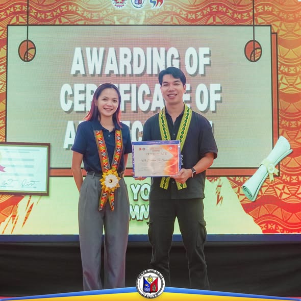 Dalawang tao habang hawak ang sertipiko sa entablado ng Naic Youth Summit 2025 Awarding of Certificate