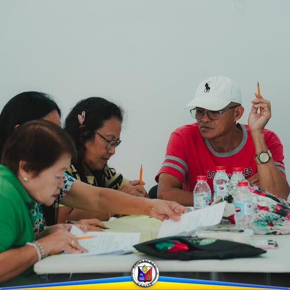 Mga kalahok sa seminar sa accounting para sa mga opisyal ng kooperatiba, nag-uusap habang may hawak na papel at lapis