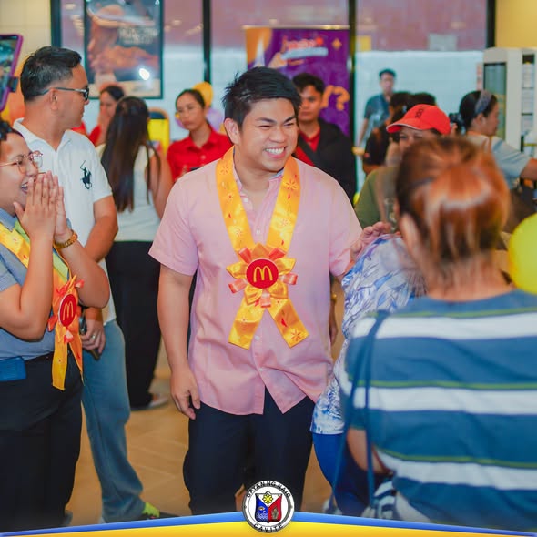 Mga tao sa loob ng bagong McDonald's sa Malainen Bago habang may nakalakad na nakasuot ng pulang-dilaw na lanyard