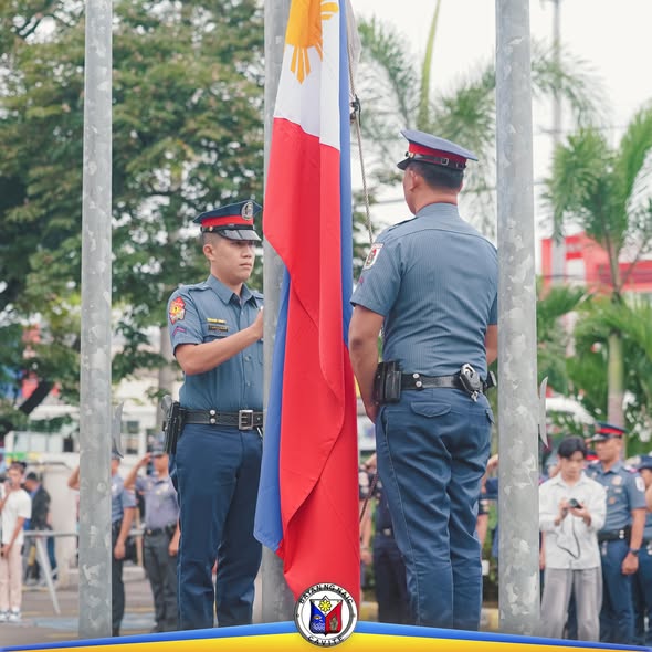 Mga pulis na nagtataas ng watawat ng Pilipinas sa flag raising ceremony sa Naic