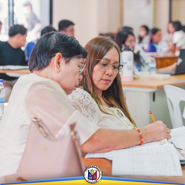 Mga kalahok na nagsusulat at nagbabasa ng mga dokumento sa isang pagpupulong ng lokal na pamahalaan