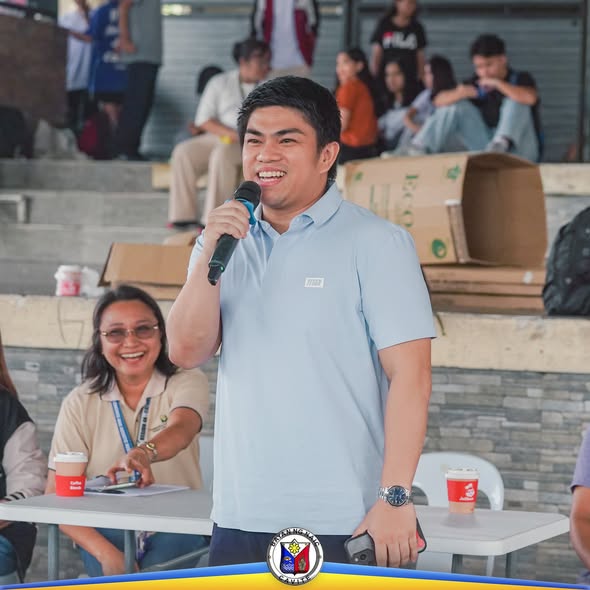 Lalaking nagsasalita sa mikropono sa outdoor na programa ng Fisherfolk Fuel Subsidy sa Naic Town Plaza