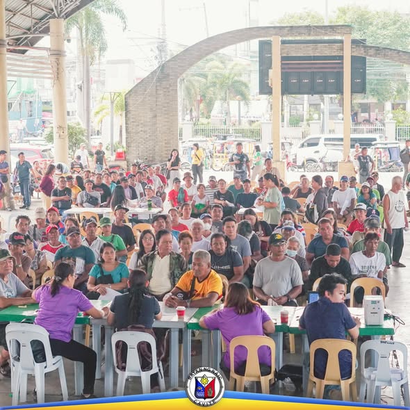 Mga mangingisda na nakapila at nakaupo sa Naic Town Plaza habang isinasagawa ang fuel subsidy program