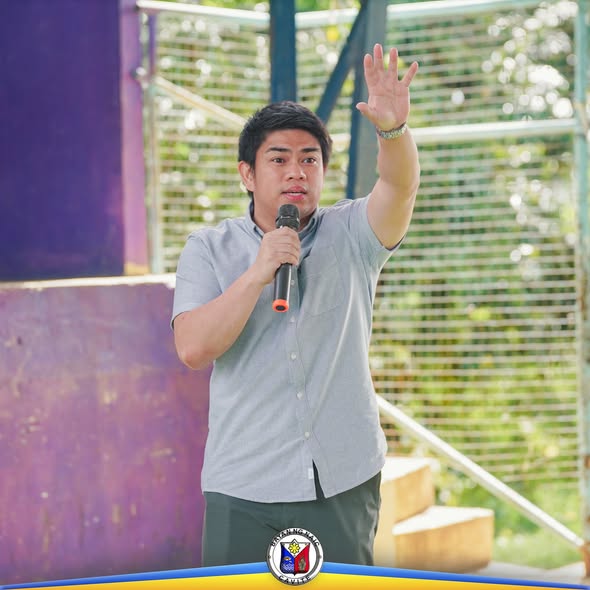 Lalaking nagsasalita gamit ang mikropono habang nakataas ang kamay sa Zero Waste assessment sa Naic