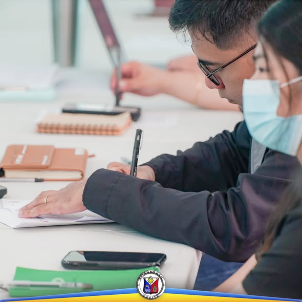 Mga dumalo sa Third Quarter MAC Meeting na abala sa pagsusulat at pagrerepaso ng mga papel sa mesa