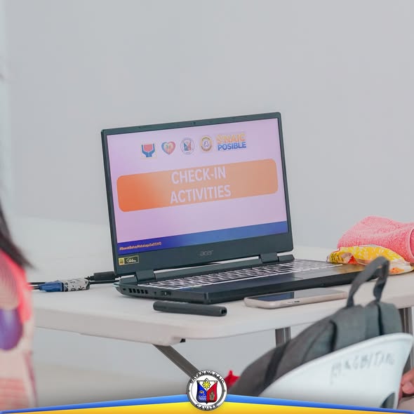 Laptop na may slide na 'Check-In Activities' sa Municipal Advisory Committee meeting sa Sabang, Naic