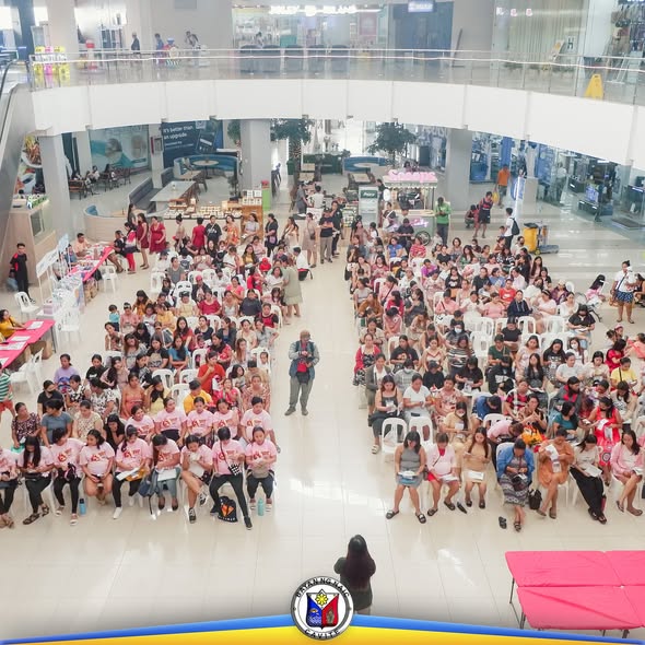 Mga dumalo sa Buntis Congress 2025 na nakaupo sa Stadium Shopping Strip, karamihan naka-pink na damit