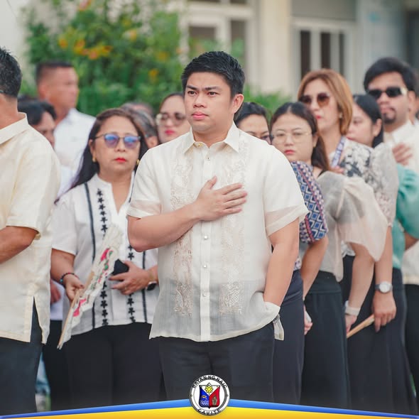 Lalaking naka-barong na nakahawak sa dibdib habang nakikiisa sa flag raising ceremony sa Naic
