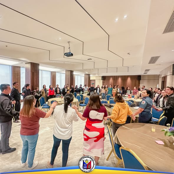 Mga kalahok ng Comprehensive Development Planning Workshop na nagkakahawakan ng kamay sa isang bulwagan sa Naic