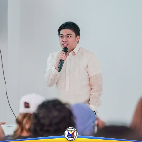 Lalaking naka-barong na nagsasalita sa mikropono sa harap ng mga dumalo sa joint organizational meeting ng mga konseho