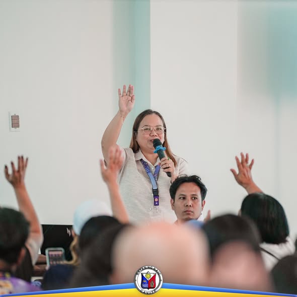 Babaeng nagsasalita sa mikropono habang nagtataas ng kamay ang mga dumalo sa Joint Organizational Meeting ng mga konseho