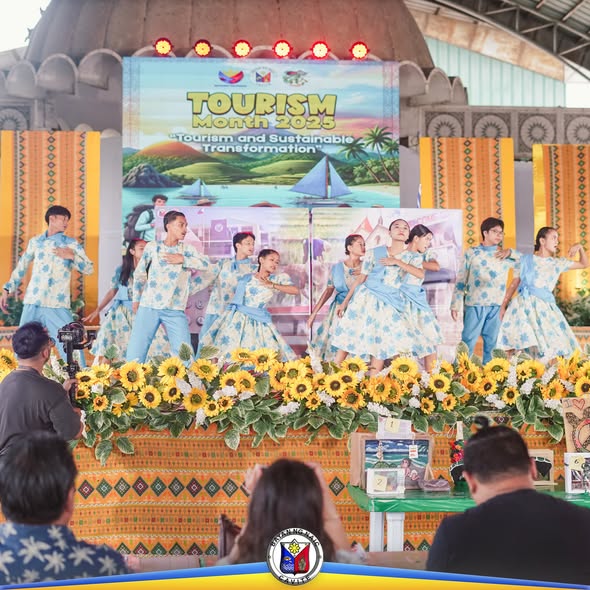 Mga mananayaw na naka-asul at puting kasuotan habang nagtatanghal sa entablado ng Tourism Month 2025 sa Naic
