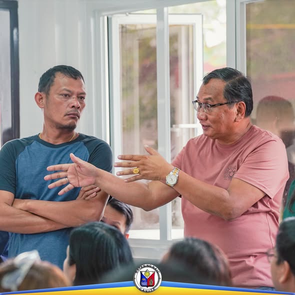Mga kalahok sa pulong habang nagsasalita ang isang lalaki at nakikinig ang kasama niya sa loob ng silid