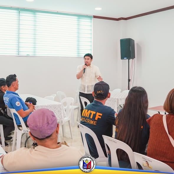 Lalaking nagsasalita sa mikropono sa harap ng mga dumalo sa Local Development Council Meeting sa Naic