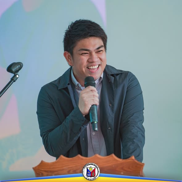 Isang lalaking nakangiti habang nagsasalita gamit ang mikropono sa podium sa isang pagsasanay sa Naic