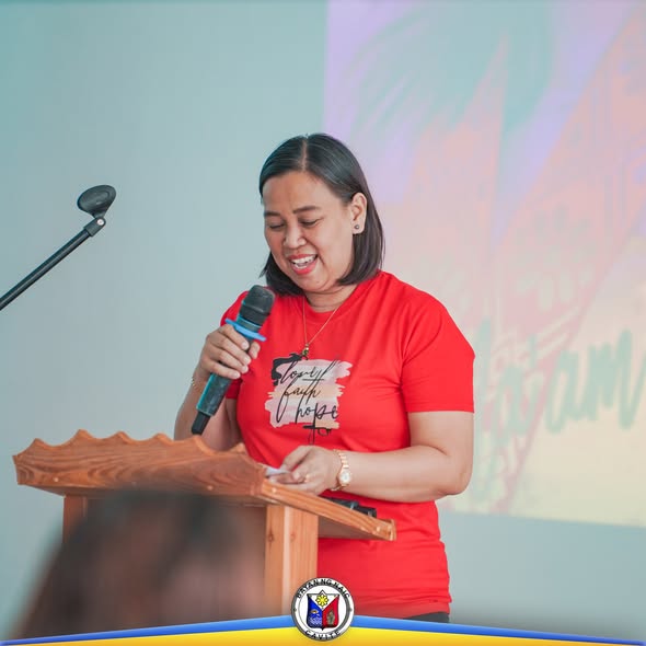 Babaeng nagsasalita sa mikropono sa podium habang nagbibigay ng mensahe sa municipal training ng Naic