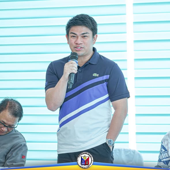 Lalaking nagsasalita gamit ang mikropono sa harap ng puting blinds sa isang pagtitipon ng mga treasurer sa Naic