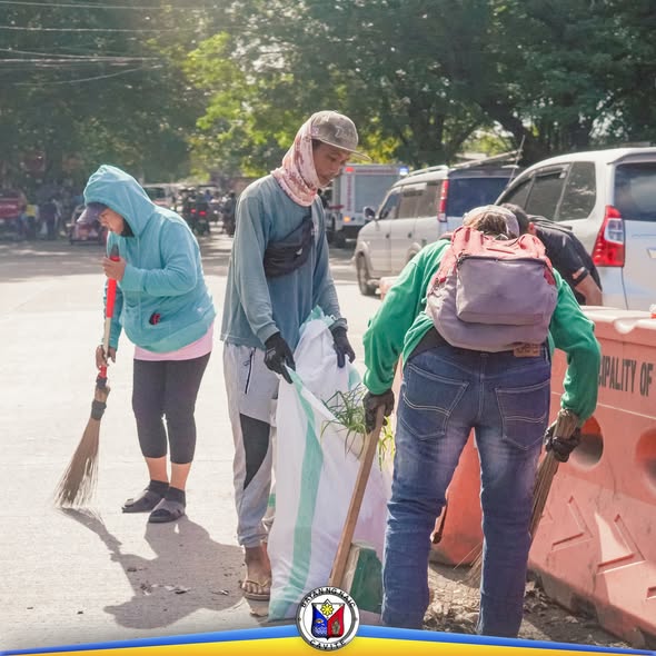 Mga residente habang naglilinis ng kalsada at nagsasako ng basura sa Hills View, Naic