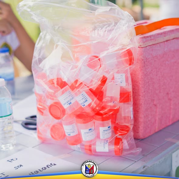 Mga bote ng bakuna sa loob ng plastic bag at cooler sa Purok Kalusugan, Barangay Halang