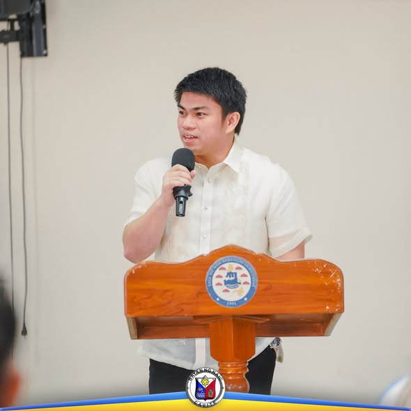 Lalaking nagsasalita sa mikropono sa podium sa pulong ng MDRRMC sa Naic