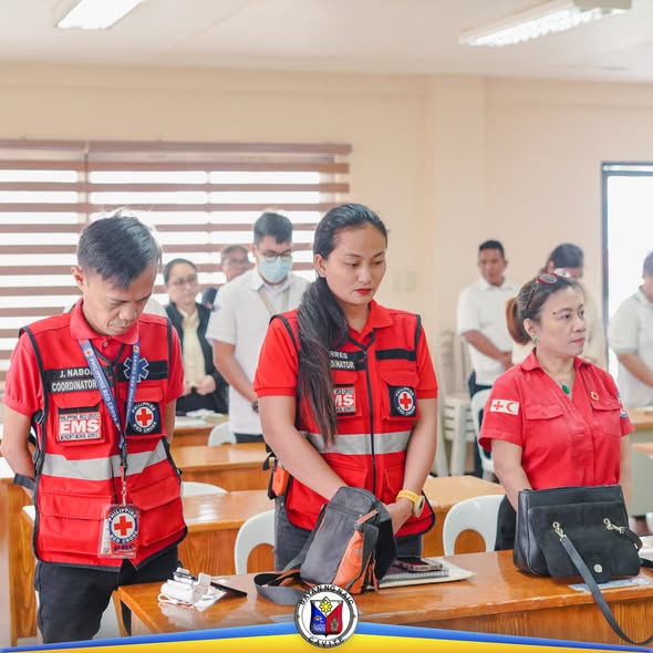 Mga kalahok ng MDRRMC 4th Quarterly Meeting na nakatayo at nakayuko sa silid pulungan ng Liga ng mga Barangay