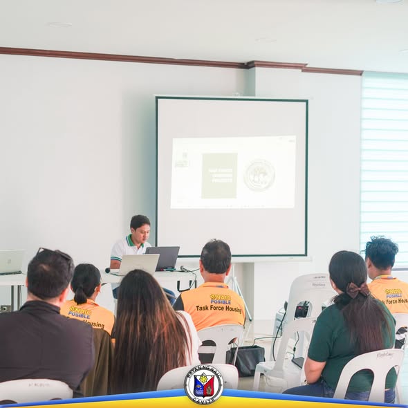 Mga dumalo sa orientation seminar ng NHA habang nakikinig sa tagapagsalita sa harap ng projector screen