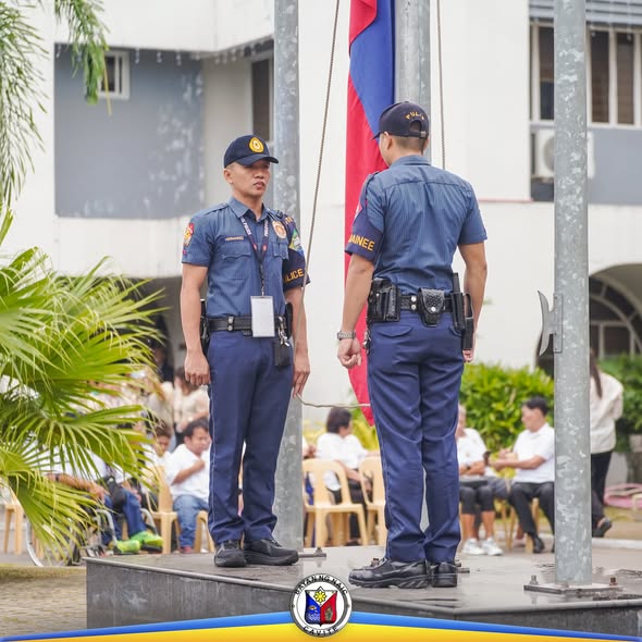 Mga pulis na nakatayo nang tuwid habang nagaganap ang flag raising ceremony sa Naic Municipal Hall