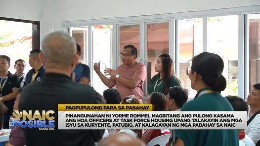 Pulong ng mga opisyal at kawani habang nagsasalita ang isang lalaki sa harap ng grupo sa loob ng hall