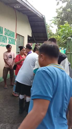 Mga tao na nagtitipon sa labas ng Bucana Sasahan Elementary School Extension para sa pamamahagi ng relief goods