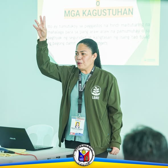 Babaeng tagapagsalita na nagpapaliwanag sa Financial Literacy Training sa harap ng screen na may slide