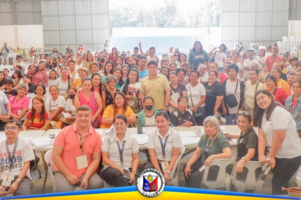 Grupo ng mga benepisyaryo at opisyal sa Triple 8 Multipurpose Hall habang nagpapakuha ng group photo