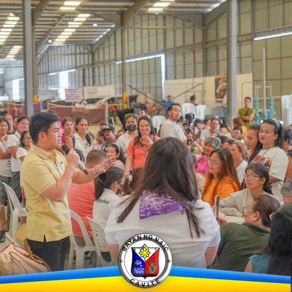 Tao na nagsasalita sa mikropono sa harap ng maraming dumalo sa tulong-puhunan para sa 4Ps graduates sa Naic