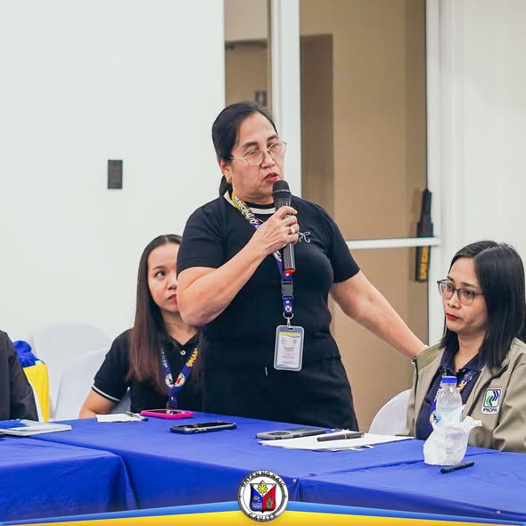 Babaeng nagsasalita sa mikropono sa entrance conference ng COA audit sa Naic, may dalawang kasama sa mesa.
