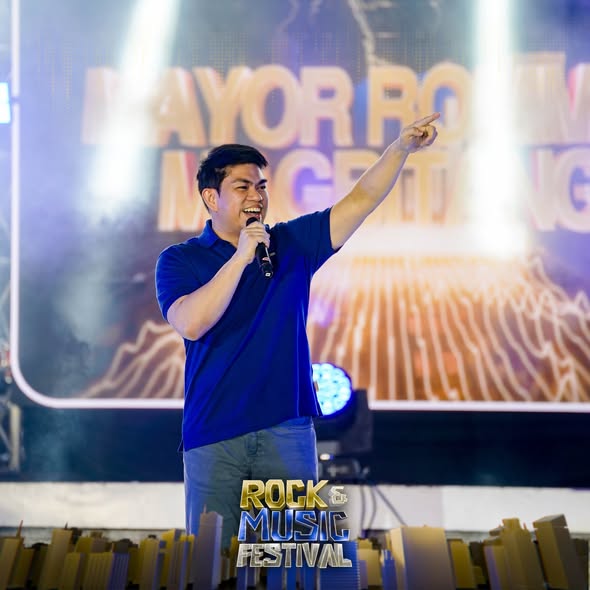 Isang lalaking nagsasalita sa mikropono at nakaturo sa entablado ng Naic Rock & Music Festival 2025