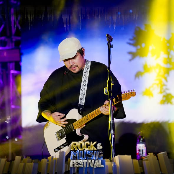 Gitarista habang tumutugtog sa entablado ng Naic Rock & Music Festival sa Naic Town Plaza