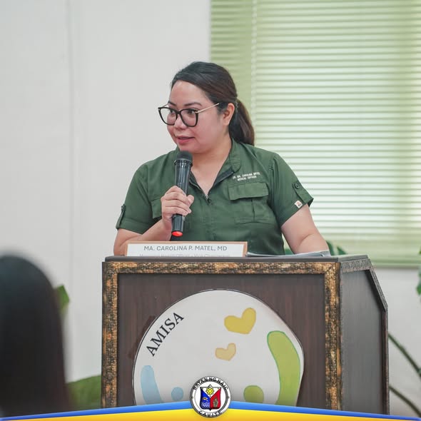 Babaeng opisyal na nagsasalita sa mikropono sa podium ng Local Health Board Meeting sa Amisa Medical Mission Hospital