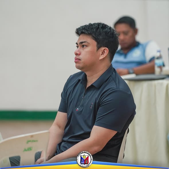 Lalaking naka-itim na polo habang nakaupo at nakikinig sa pulong ng Local Health Board sa Naic