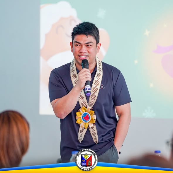 Lalaking nagsasalita sa mikropono sa harap ng screen sa pagpupulong ng mga budget officer sa Naic