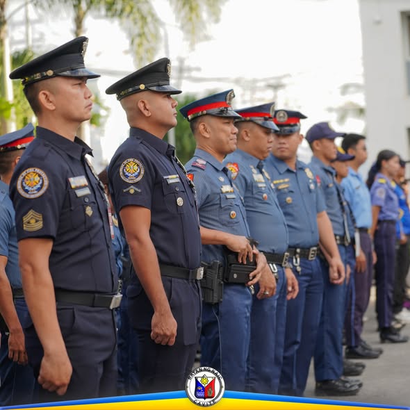 Mga uniporme ng kapulisan na nakahanay at nakatayo nang tuwid sa seremonya ng pagtataas ng watawat