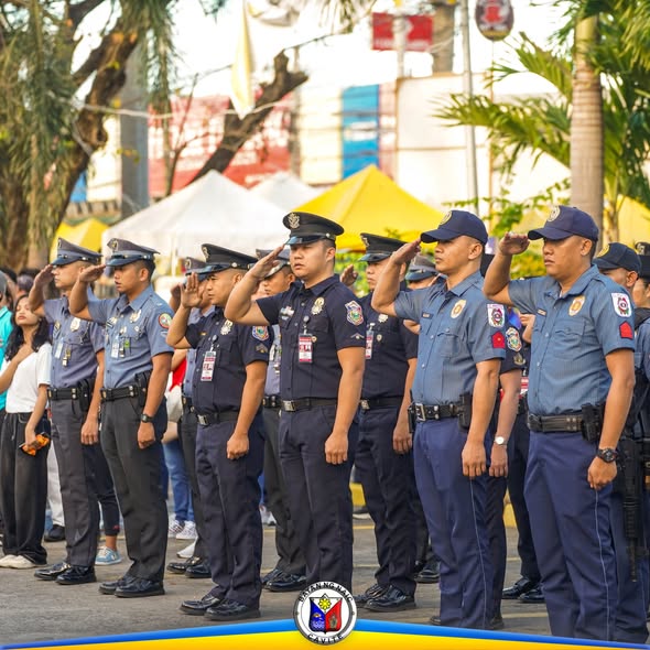 Mga uniformadong tauhan na nagsasaludo habang tumutugtog ang pambansang awit sa flag raising ceremony sa Naic