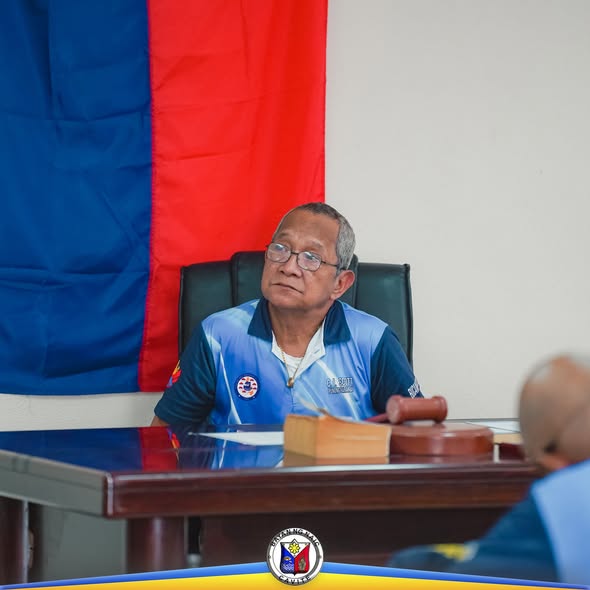 Pulong ng Liga ng mga Barangay sa Naic; lalaking nakaupo sa mesa habang may gavel at nagpupulong