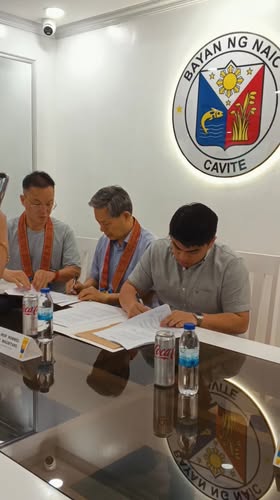 Mga kalalakihan na pumipirma ng kontrata sa mesa sa Naic Municipal Hall para sa Korea–Naic Friendship Infirmary