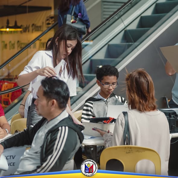 Mga tao sa BOSS na nag-aasikaso ng papeles sa Stadium Shopping Strip, Naic