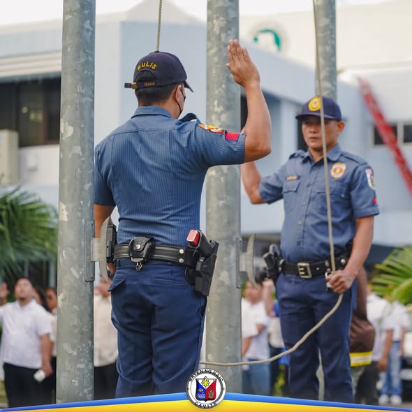 Mga uniformed na kawani habang nagsasaludo sa flag raising ceremony sa Naic Municipal Hall