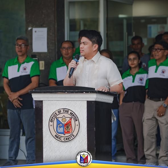 Mayor na nagsasalita sa podium habang nakikinig ang mga kawani sa Flag Raising Ceremony sa Naic