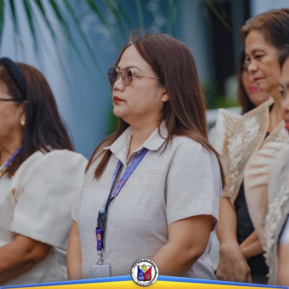 Mga kalahok na nakatayo sa seremonya ng flag raising sa Naic Municipal Hall, may suot na lanyard at puting damit