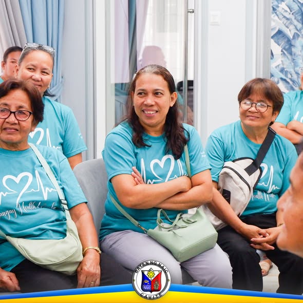 Mga miyembro ng Barangay Health Workers na nakaupo at nakikinig sa seremonya sa Naic Municipal Hall