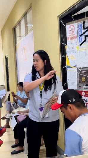 Isang staff na nagbibigay ng paliwanag sa mga tao sa SSS Caravan sa loob ng opisina ng Naic