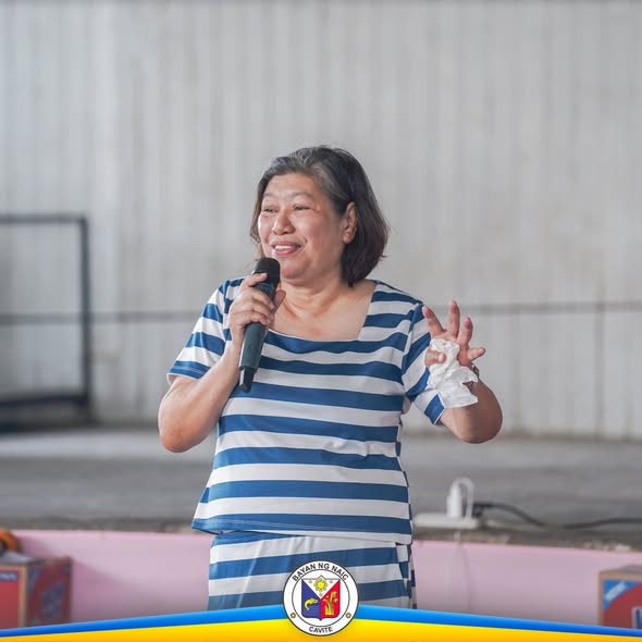 Babaeng nagsasalita gamit ang mikropono sa Solo Parents Week Celebration sa Naic Covered Court