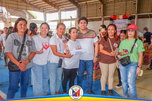 Mga dumalo sa Solo Parents Week celebration na nagpose sa covered court ng Naic habang may hawak na card